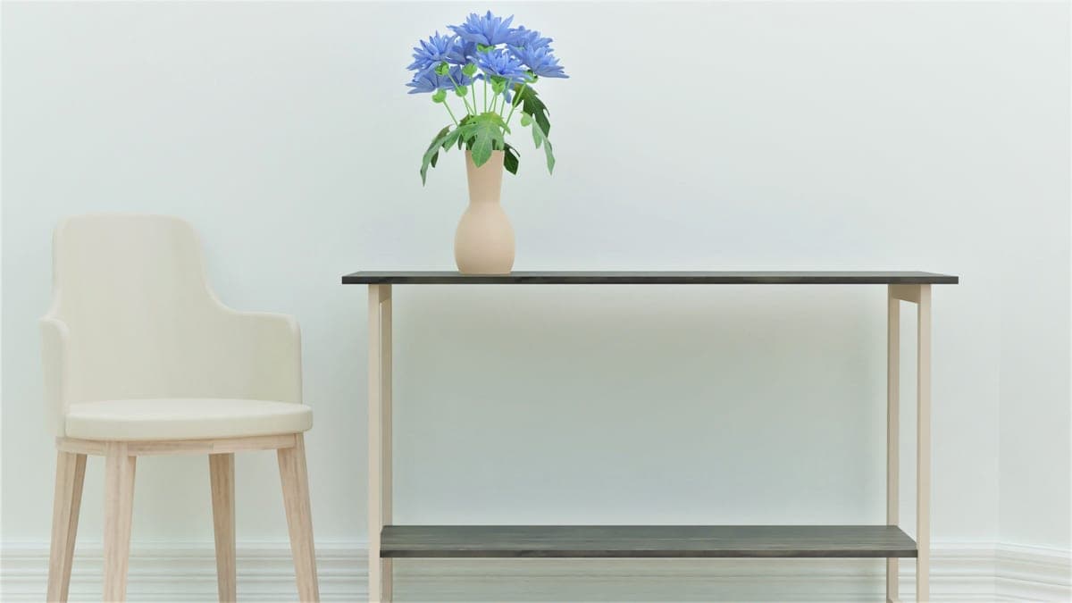 A simple two-shelf serving trolley holding a few bottles against a pale wall